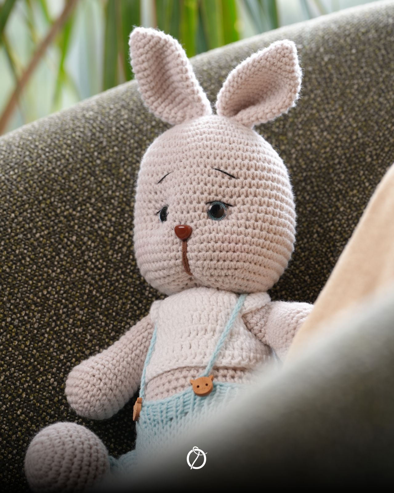 Cream crochet bunny wearing light-blue overalls with wooden bear buttons
