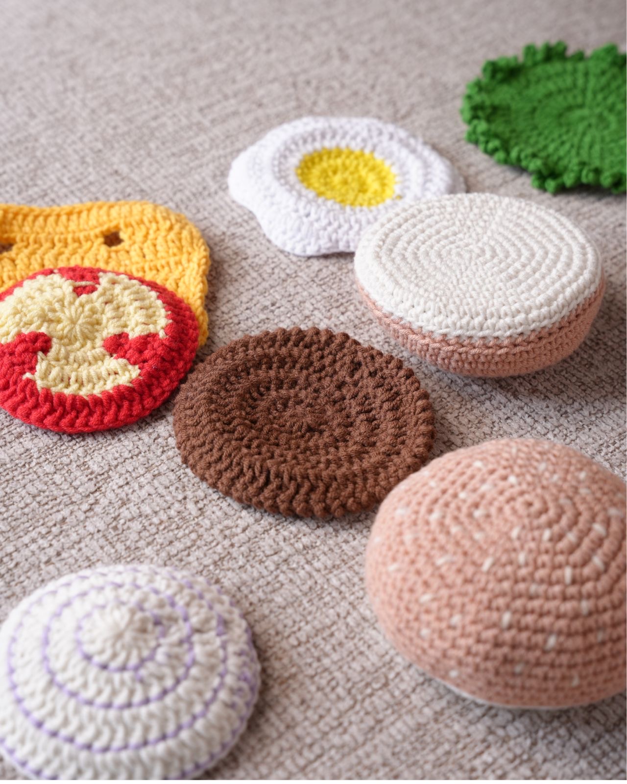 Play hamburger pieces laid out: buns, patty, cheese, tomato, lettuce, egg and onion